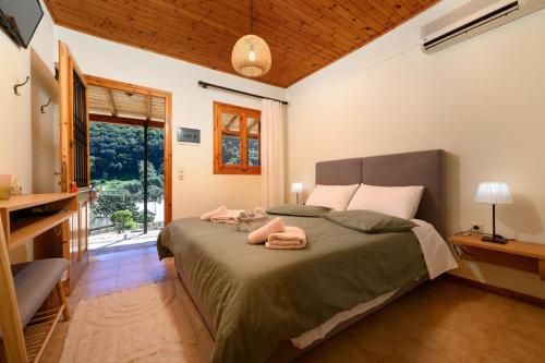 een slaapkamer met een bed met twee handdoeken erop bij Pieros Studios Alipa in Paleokastritsa