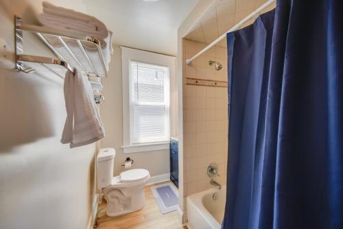 baño con aseo y cortina de ducha azul en Modern Portsmouth Apartment Walk to Norfolk Ferry, en Portsmouth