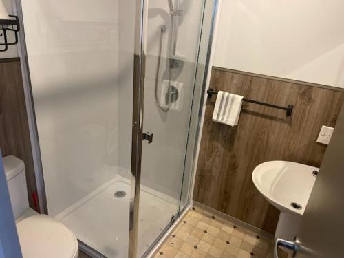 e bagno con doccia, servizi igienici e lavandino. di Conway Motel Manukau ad Auckland