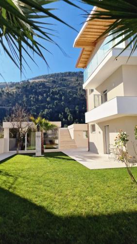 a house with a grass yard in front of it at Apartaments Mimani 2 in Berat