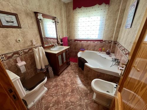 y baño con bañera, aseo y lavamanos. en Casa Rural Las Eras de Campotejar, 