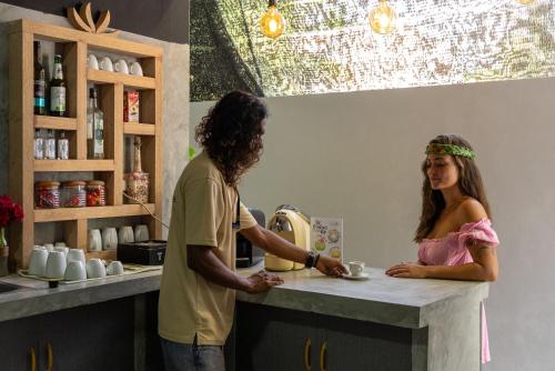Omadhoo的住宿－Hitha Maldives，站在厨房柜台上的男人和女人
