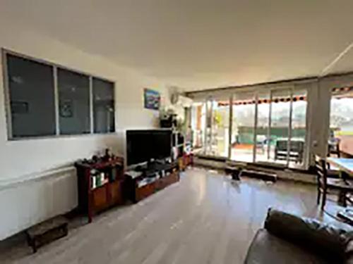 ein großes Wohnzimmer mit Sofa und TV in der Unterkunft Logement spacieux avec terrasse in Aix-en-Provence