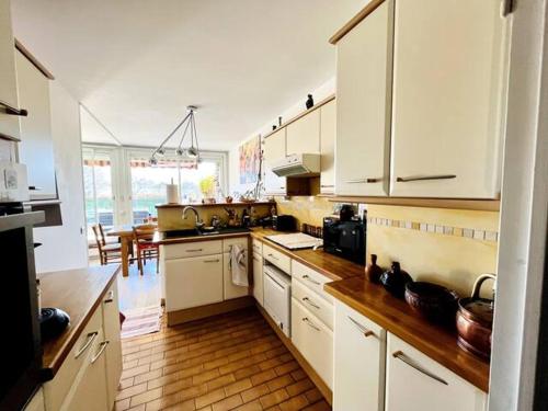 eine Küche mit weißen Schränken und Holzböden in der Unterkunft Logement spacieux avec terrasse in Aix-en-Provence