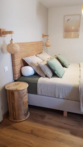 - une chambre avec un lit doté d'oreillers et d'un tabouret en bois dans l'établissement Les chambres d'hôte de la Maison de France, à Mèze