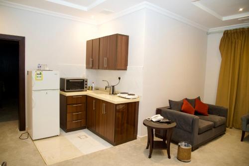 فندق أصداء الراحة Asdaa Alraha Hotel في جدة: غرفة معيشة مع أريكة ومطبخ