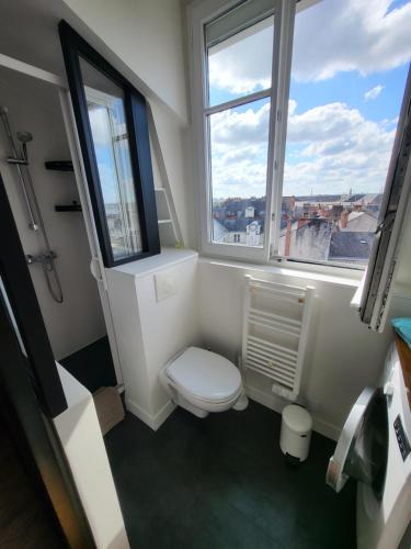 une salle de bain avec toilettes et fenêtre dans l'établissement Hyper centre de NANTES, dernier étage vue exceptionnelle, à Nantes
