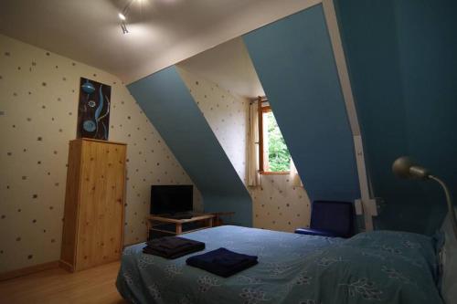 La Milesse的住宿－Maison des bois - La pause des 24 heures du Mans，一间卧室配有一张蓝色墙壁的床和一扇窗户