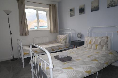 a bedroom with two beds and a window at Snowdon Snug 2.0 in Llanberis