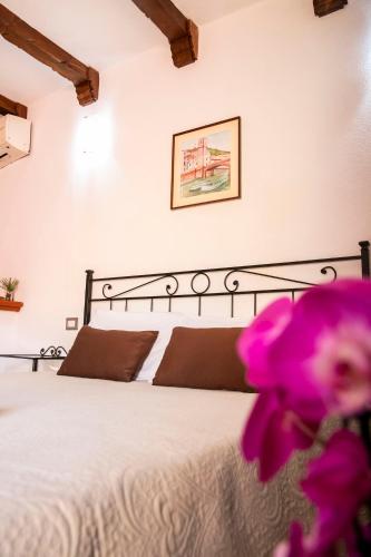 a bedroom with a bed with a purple flower at La Torre del Pozzo Guest House in Bosa