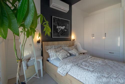 een slaapkamer met een bed en een plant bij Alex Suites Lara in Antalya