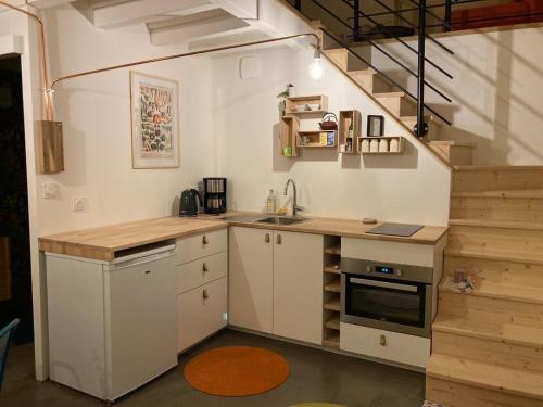 eine Küche mit einer Theke, einem Waschbecken und einer Treppe in der Unterkunft Le 6 