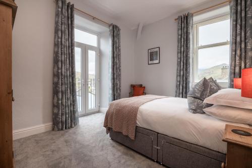 een slaapkamer met een bed en een groot raam bij Wansfell Heights in Ambleside