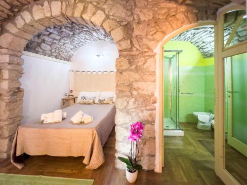 ボーザにあるLa Torre del Pozzo Guest Houseの石壁のベッドルーム1室