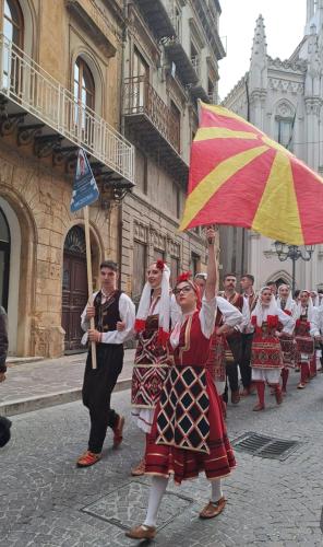 a group of people walking down a street holding an umbrella at KALGHEROS Luxury Rooms in Agrigento