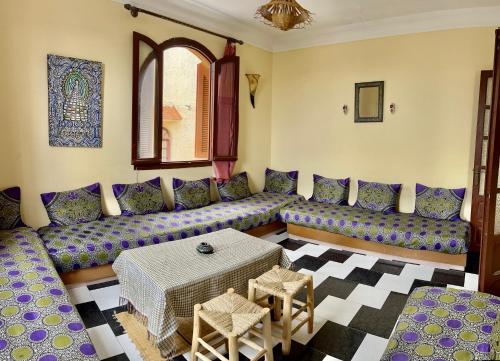 una sala de estar con sofás morados y una mesa. en soleado apartamento al lado de la preciosa medina , a 3 minutos de la playa andando II, en Asilah