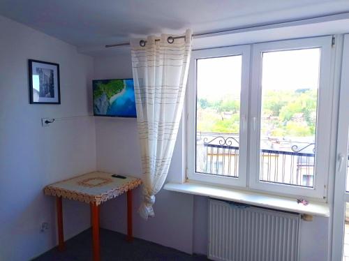 a room with a window with a bench and a table at Gdańsk tanie noclegi pokój z balkonem z widokiem na morze nr 12 1-3 osobowy in Gdańsk