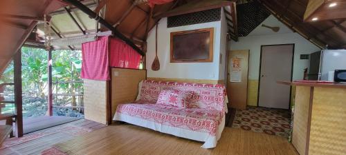 um quarto com uma cama numa casa em La Pirogue chez l'Happy qui chante em Haapiti