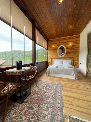 a bedroom with a bed and a table and some windows at Aho dağ manzaralı oda in Trabzon