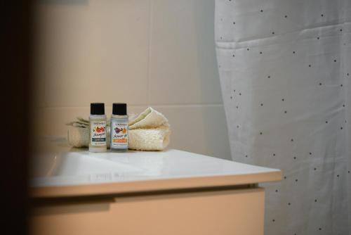 two bottles of essential oils sitting on a counter in a bathroom at Pieros Studio Tsimis in Paleokastritsa