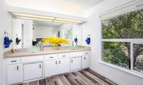 a bathroom with white cabinets and a large window at Sierra River House 5 min to Sequoia Park Entrance in Three Rivers