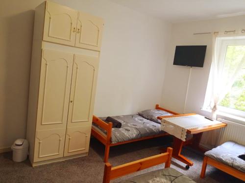 a bedroom with a bed and a cabinet and a desk at Gdańsk tanie noclegi pokój nr 7 1-4 osobowy z łazienką na korytarzu in Gdańsk