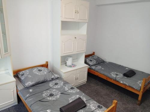 two twin beds in a room with white cabinets at Gdańsk tanie noclegi pokój nr 7 1-4 osobowy z łazienką na korytarzu in Gdańsk