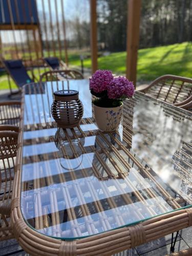 a glass table with two vases with purple flowers on it at SZUMI ROSA in Majdan