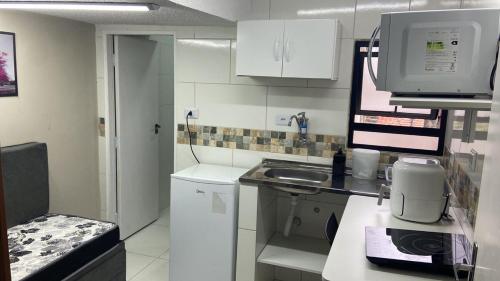 a small kitchen with a sink and a microwave at 52 LOFT quadruplo · LOFT perto da São Paulo EXPO edo metrô Jabaguara in São Paulo