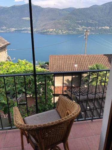 a chair sitting on a balcony with a view of the water at Come Relax and Enjoy the Breathtaking Views in Brissago