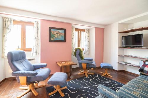 ein Wohnzimmer mit 3 Stühlen und einem TV in der Unterkunft Come Relax and Enjoy the Breathtaking Views in Brissago