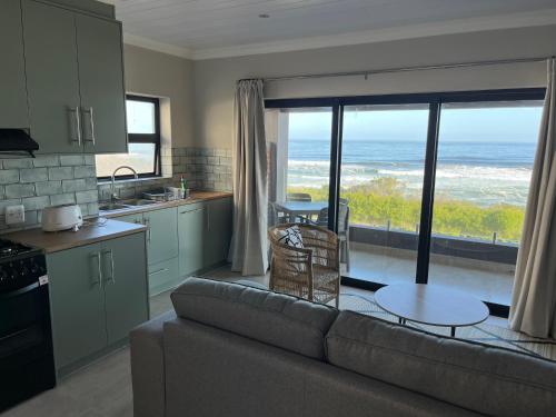 a kitchen and living room with a couch and a table at White Sands Self-catering units in Wilderness