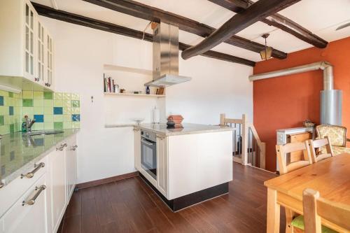 a kitchen with white cabinets and a wooden table at Come Relax and Enjoy the Breathtaking Views in Brissago