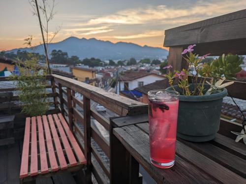 a drink sitting on a wooden table on a balcony at Casa Satoshi in San Cristóbal de Las Casas