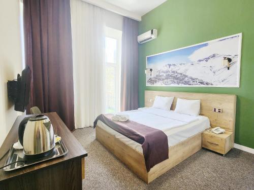 um quarto com uma cama com uma parede verde em ELYSIUM HOTEL em Baku