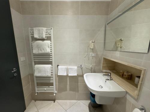 a bathroom with a sink and a toilet and towels at Hotel Holidays in Roccaraso
