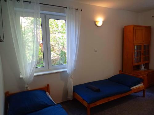 1 dormitorio con 2 camas y ventana en Gdańsk tanie noclegi pokój nr 2 1-3 osobowy z łazienką na korytarzu, en Gdansk