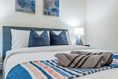 a bedroom with a bed with blue pillows on it at Fort York Apartments in Toronto
