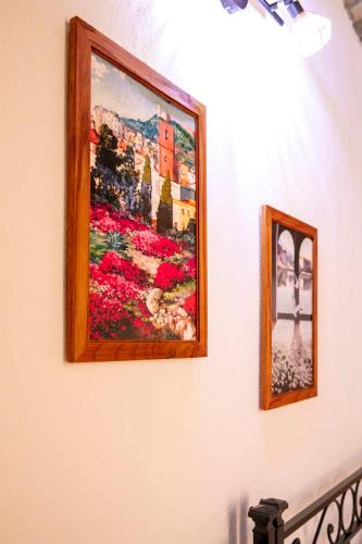 two pictures of flowers on a wall at La Torre del Pozzo Guest House in Bosa