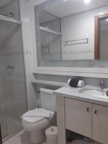 Solar das Esmeraldas - Apto 105 في غرامادو: حمام مع مرحاض ومغسلة ومرآة