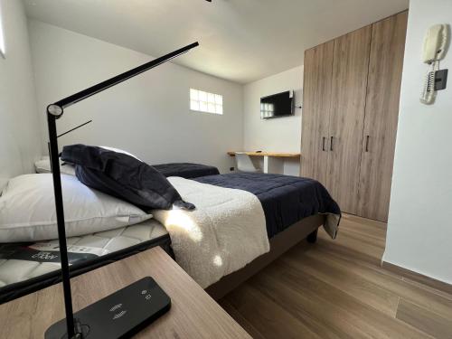 a small bedroom with a bed and a desk at AH alojamientos in Antofagasta