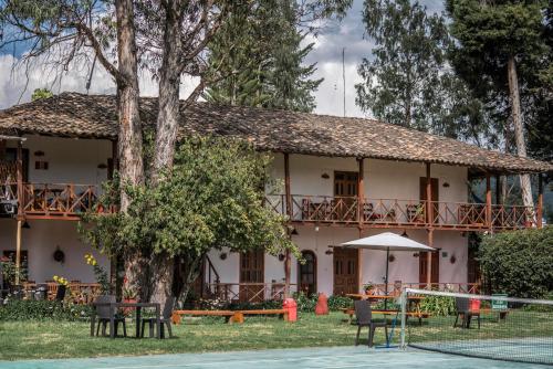 uma casa com mesas e cadeiras em frente em ART HOUSE Hacienda San Antonio em Cajamarca