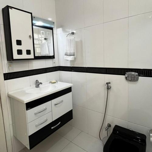 uma casa de banho com um lavatório, um espelho e um WC. em Pousada Pé na Areia Rio das Ostras em Rio das Ostras