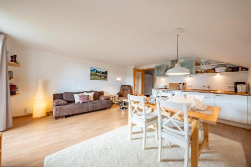 cocina y sala de estar con mesa y sillas en Weissnhof, en Samerberg