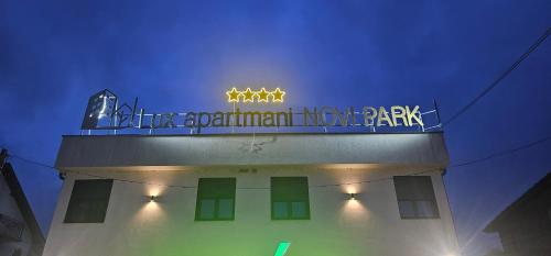 a building with a neon sign on top of it at Lux Apartmani Novi Park in Vrdnik