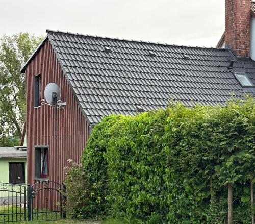 a red barn with a window and a chimney at Kuestenkind in Lobbe