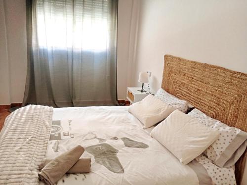 Una cama con sábanas blancas y almohadas en un dormitorio. en AMPLIO, LUMINOSO Y MODERNO II, en Calasparra