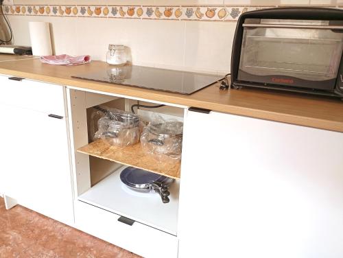 Un horno microondas colocado encima de una encimera. en AMPLIO, LUMINOSO Y MODERNO II, en Calasparra