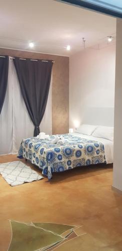 a bedroom with a bed with a blue and white blanket at CasaAlma in Serdiana