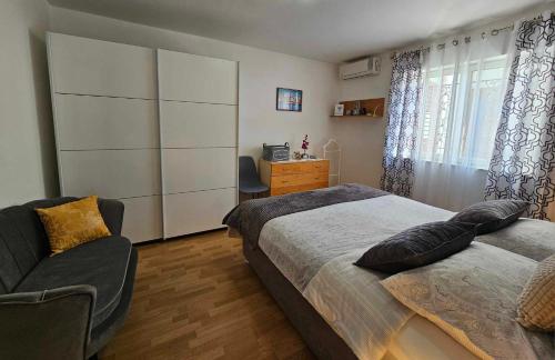 una camera con due letti, una sedia e un comò di Apartmani Rita Kiwi a Novigrad Istria